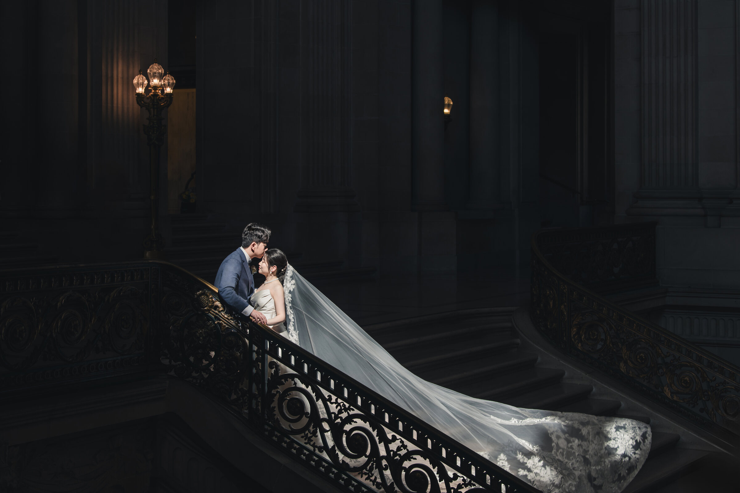 Cinematic veil portrait on a dark staircase
