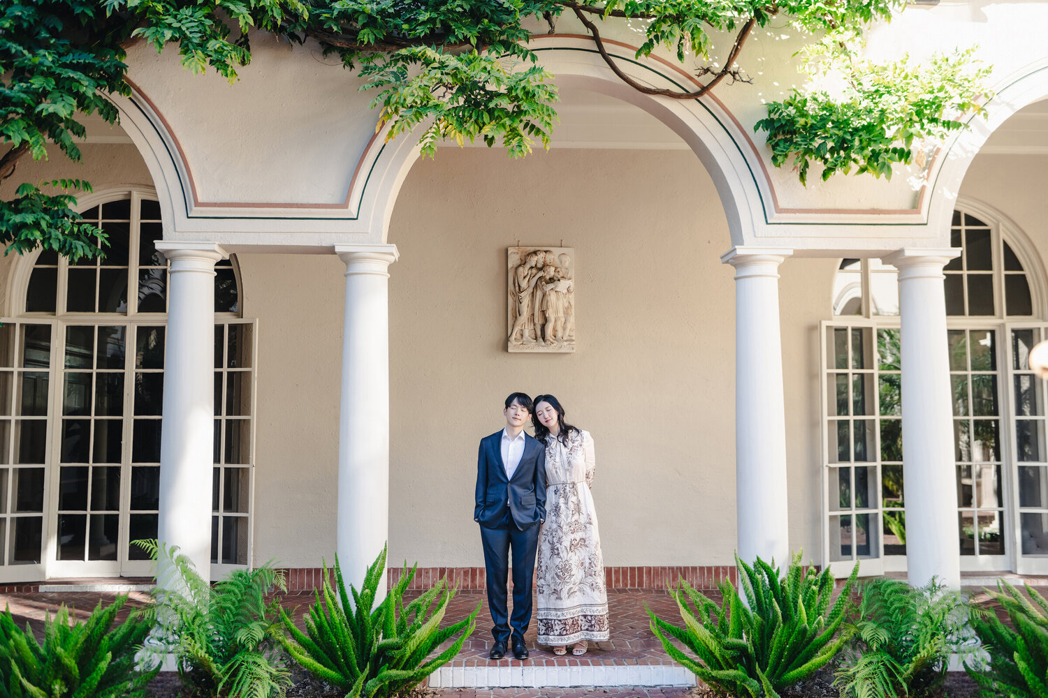 Environmental parent portrait beneath an estate porch