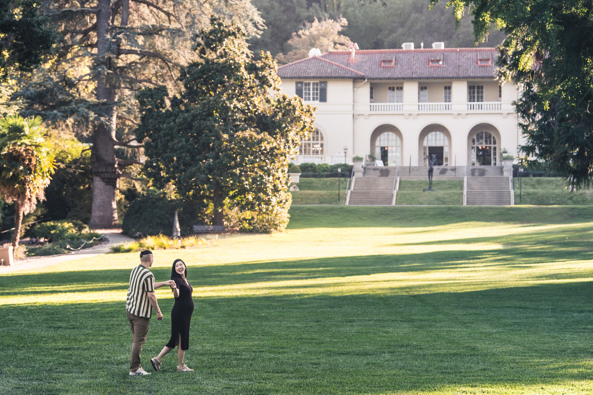 Wide environmental maternity portrait on an estate lawn