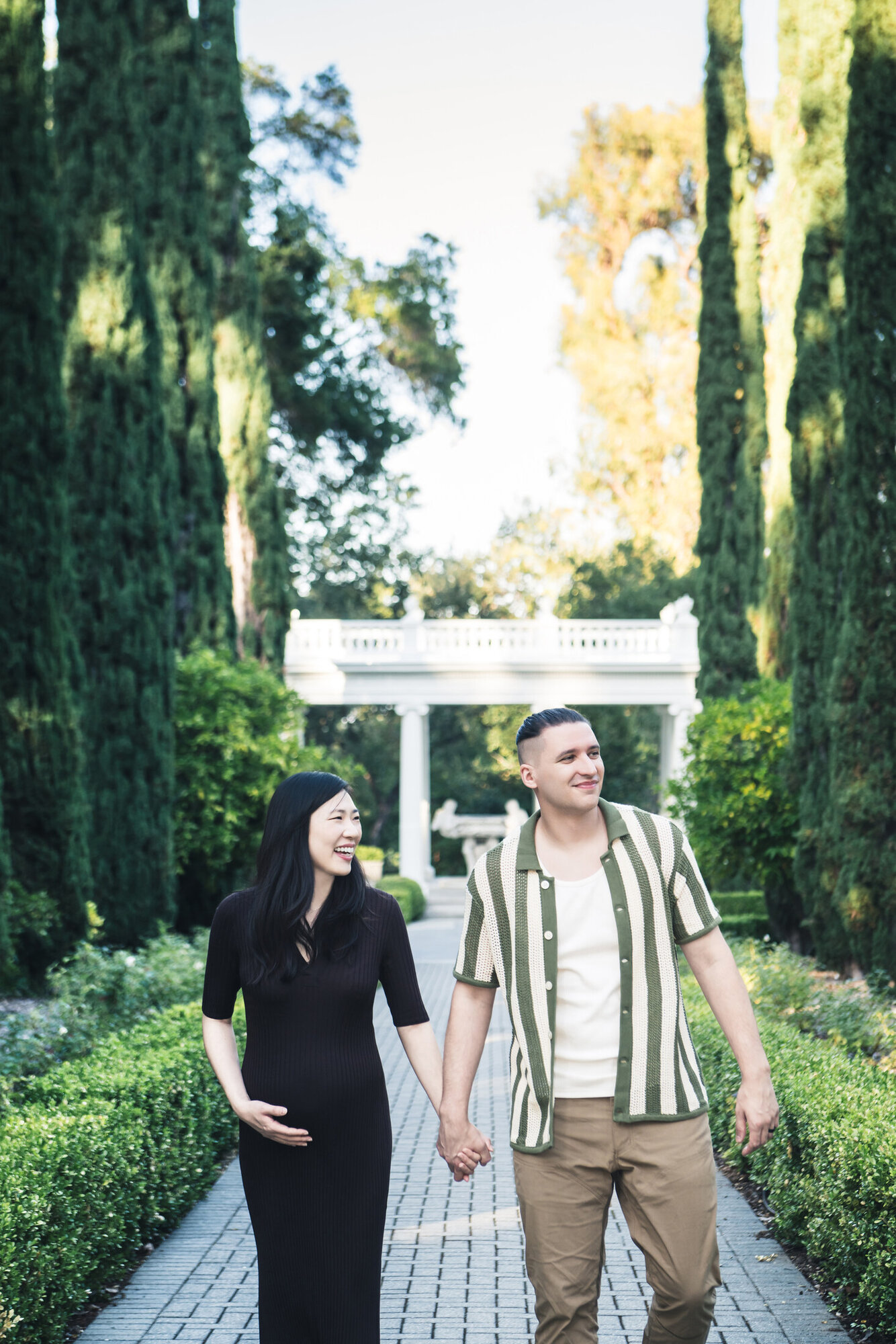 Outdoor maternity portrait walking through a garden