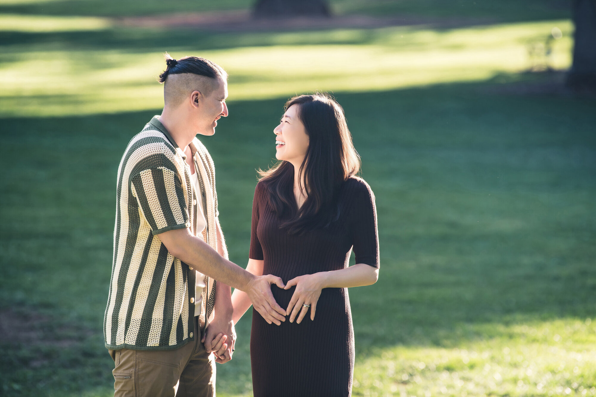 Sunlit outdoor maternity portrait with partner