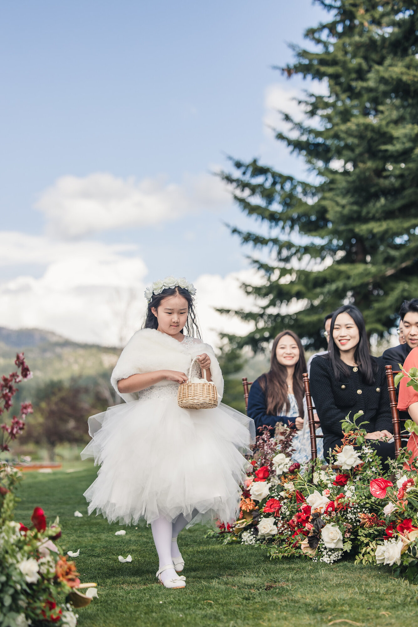 Flower girl walking down the lakefront ceremony aisle
