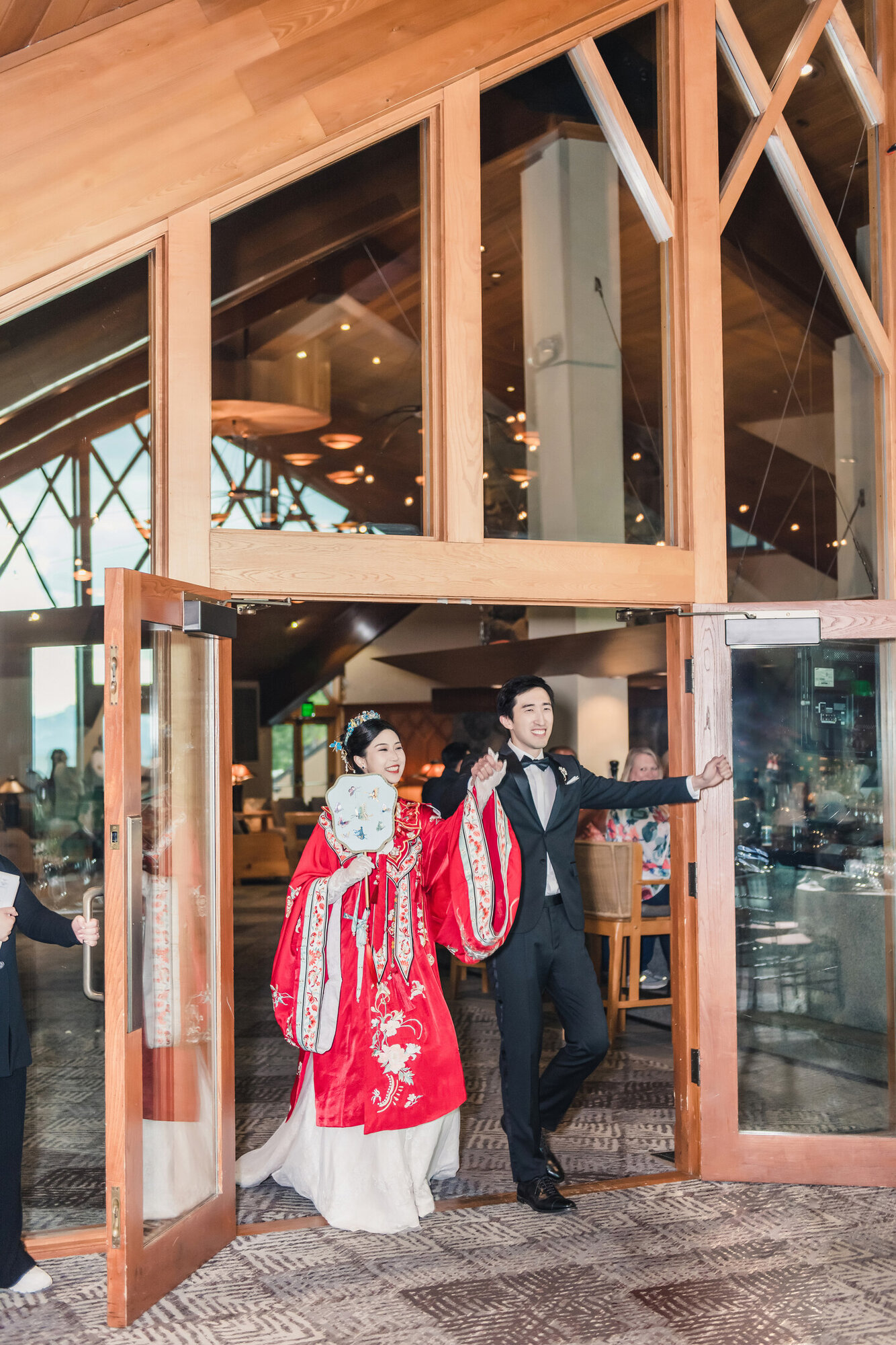 Couple entering the reception in red wedding attire