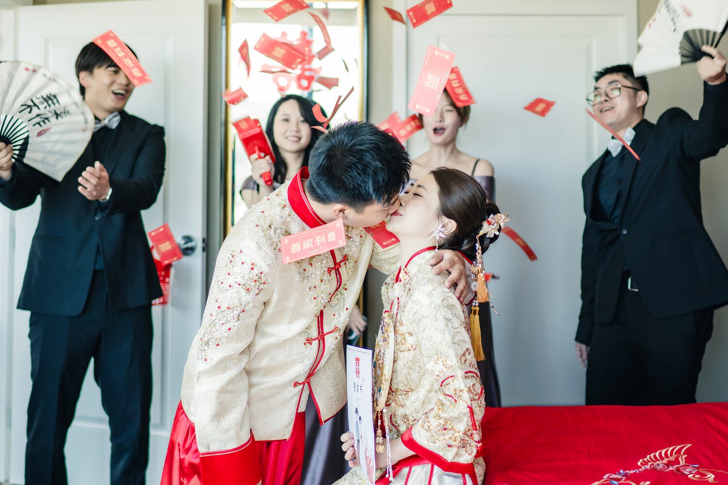 Joyful Chinese wedding door game moment with red envelopes in the air