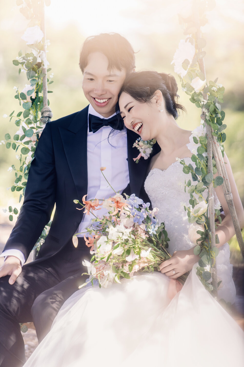 Couple laughing beneath the ceremony arch