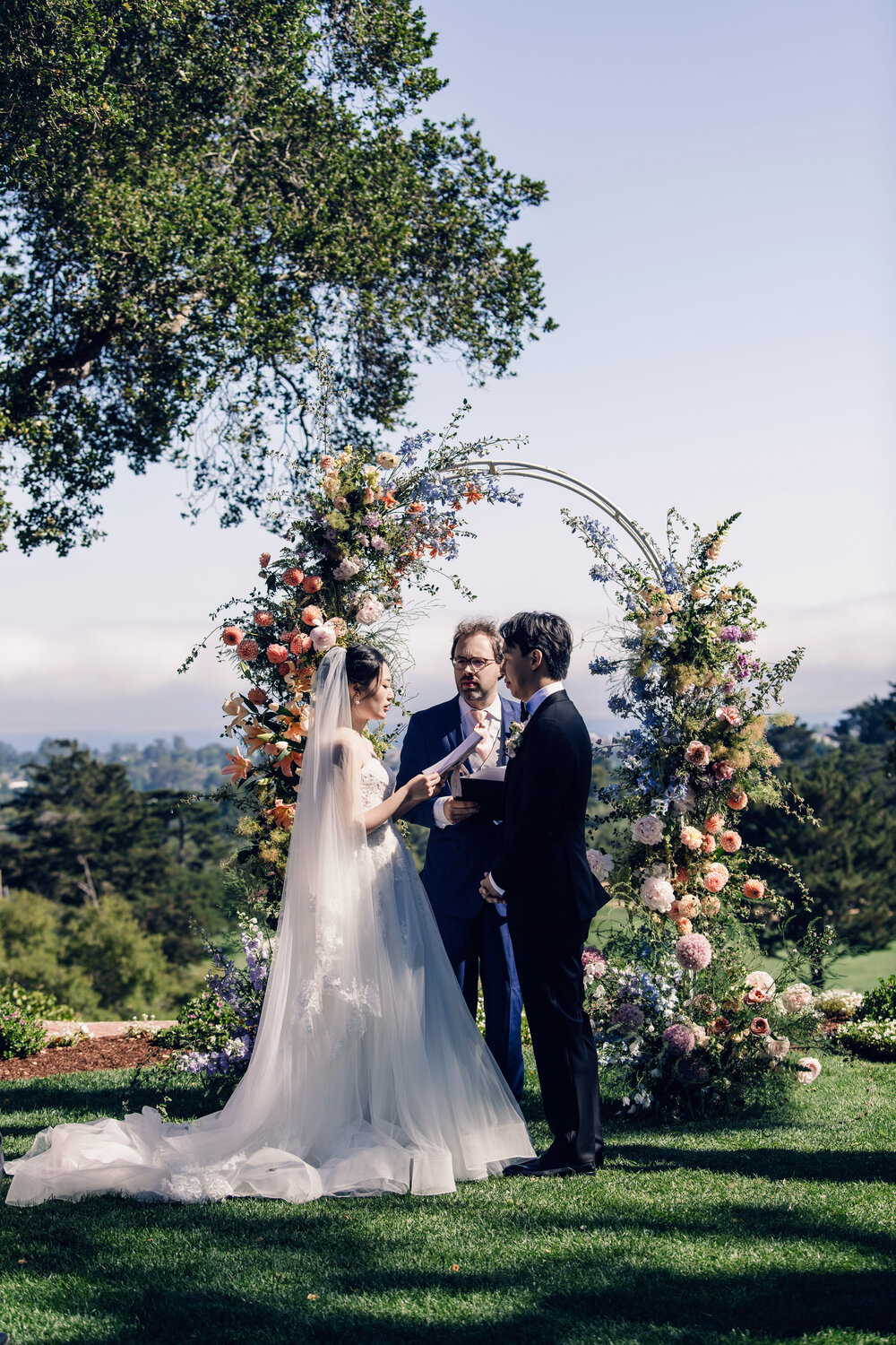 Couple standing beneath the ceremony arch