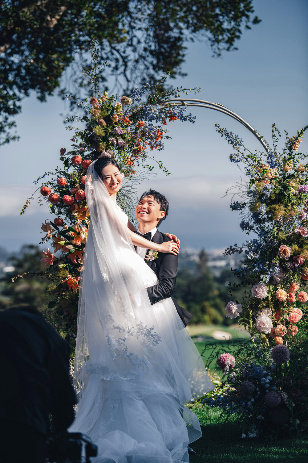 Joyful couple portrait beneath the floral arch