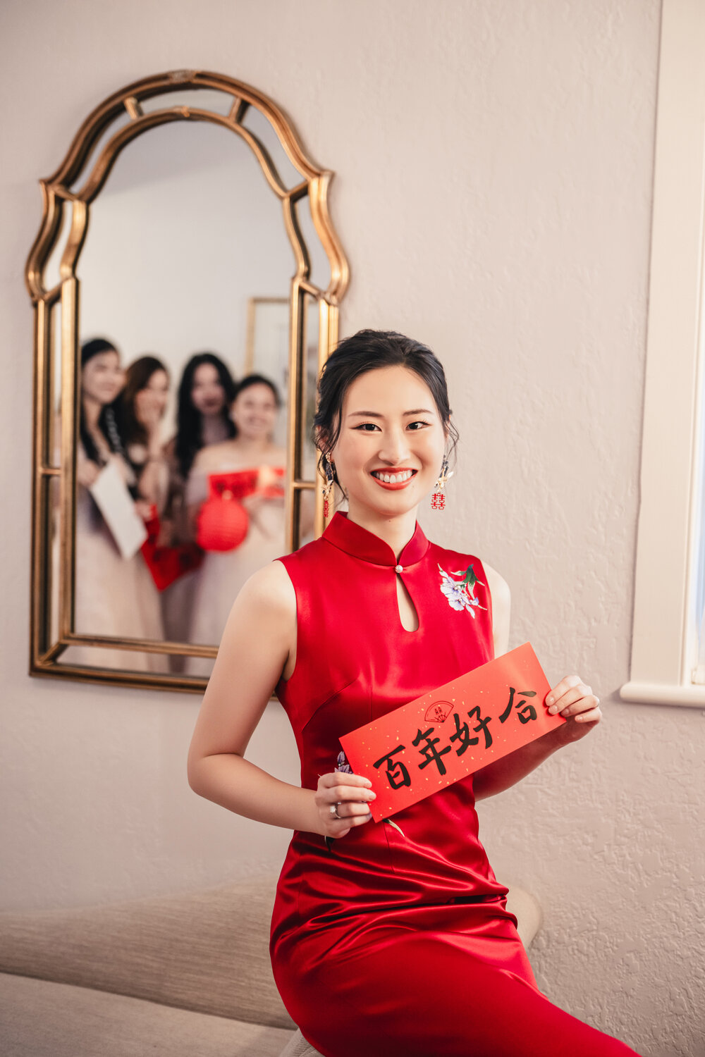 Bride in red dress holding tea ceremony signs