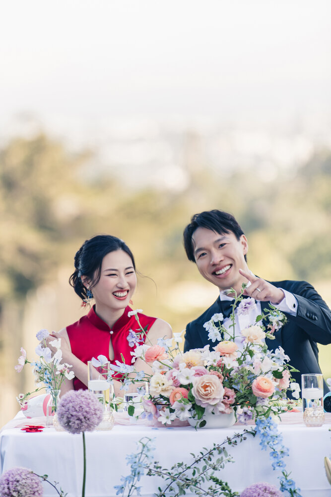Couple in red dress seated at the reception table