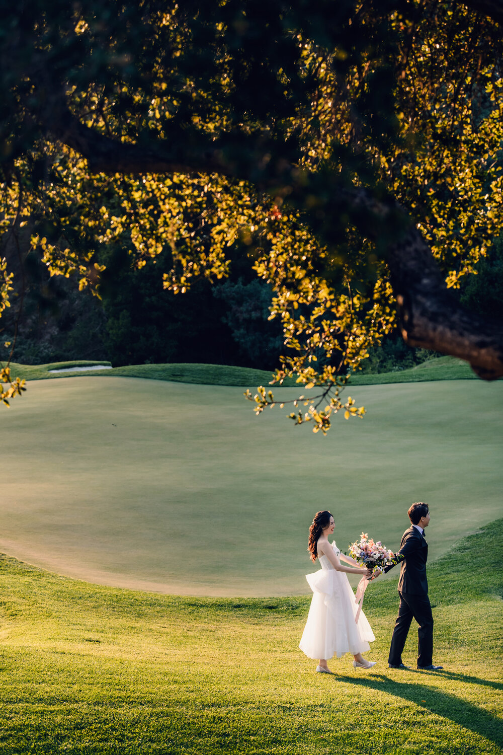 Small couple portrait beneath sunlit trees