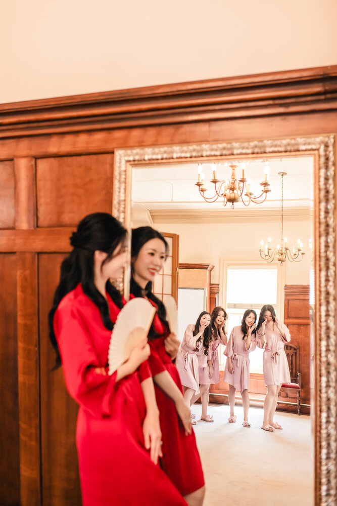 Bride in a red robe by the mirror