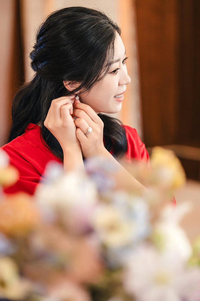 Bride putting on earrings