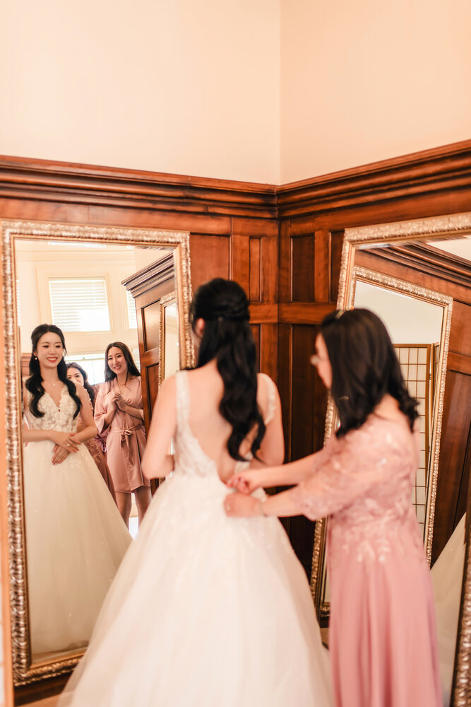 Bride and bridesmaids by the mirror