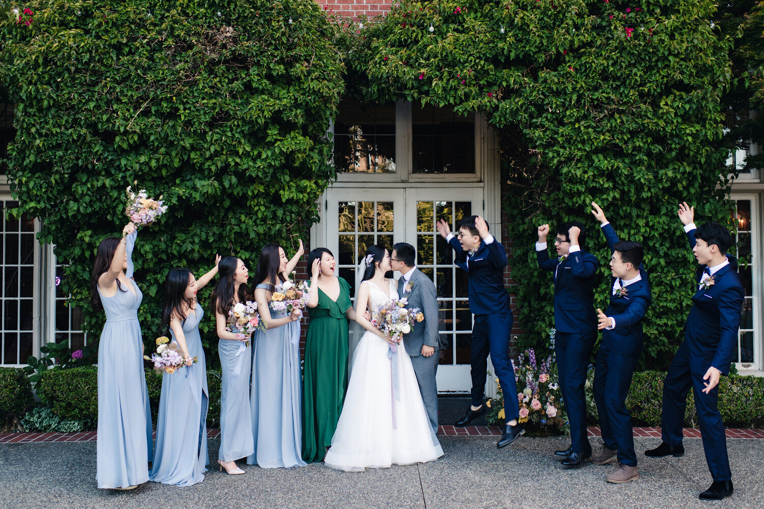 Wedding party cheering outside the mansion