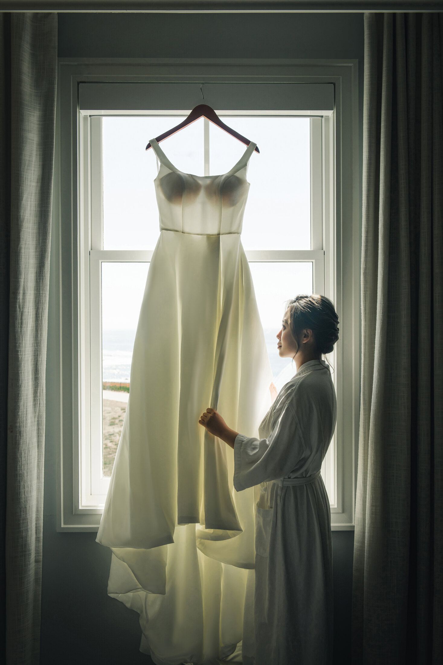 Wedding dress hanging by the window