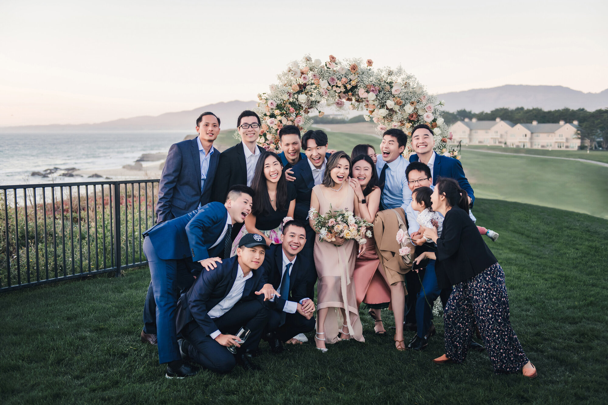 Wedding party portrait by the floral arch