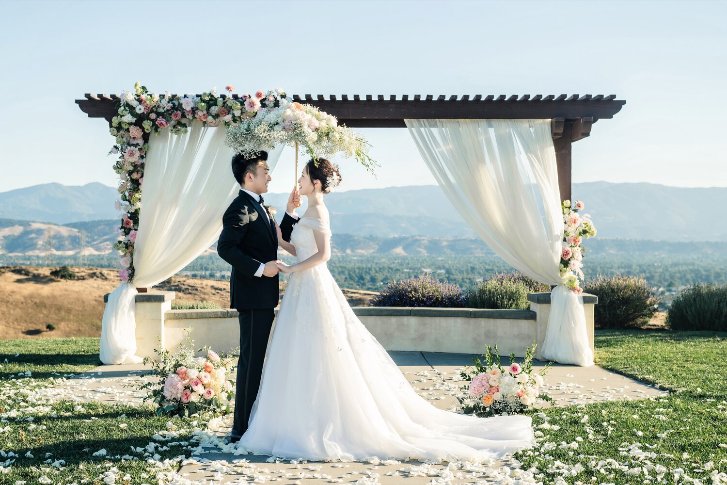Couple seated beneath the floral arch