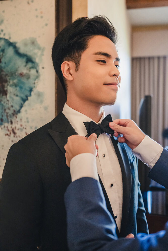Groom adjusting his bow tie