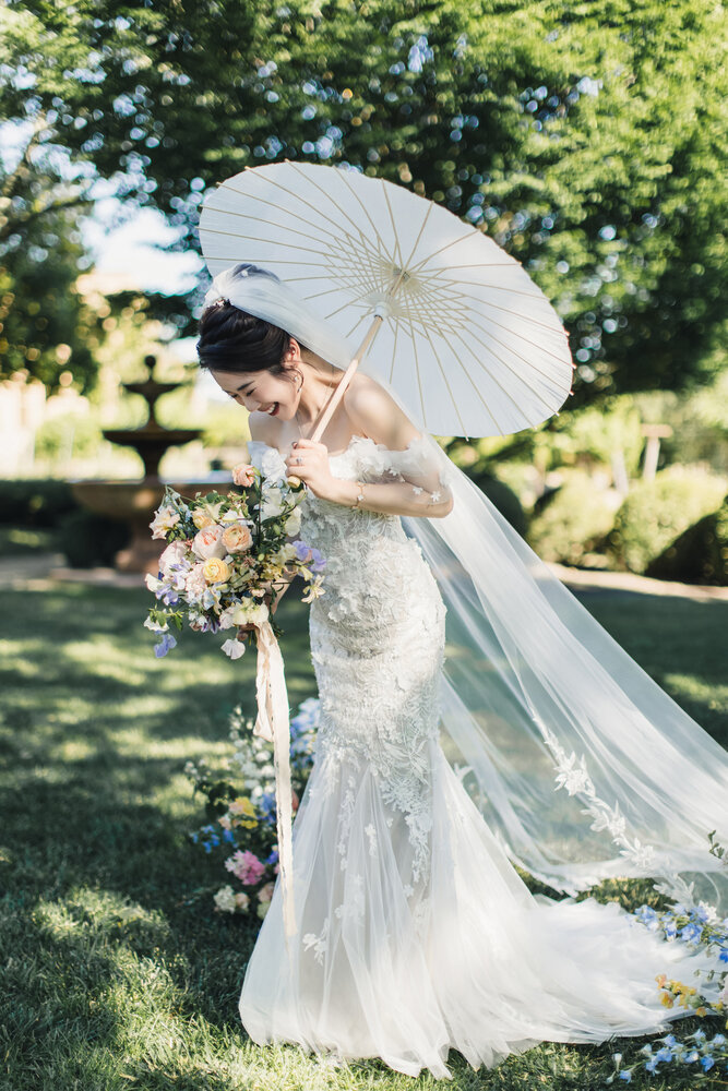Bride with parasol in garden light