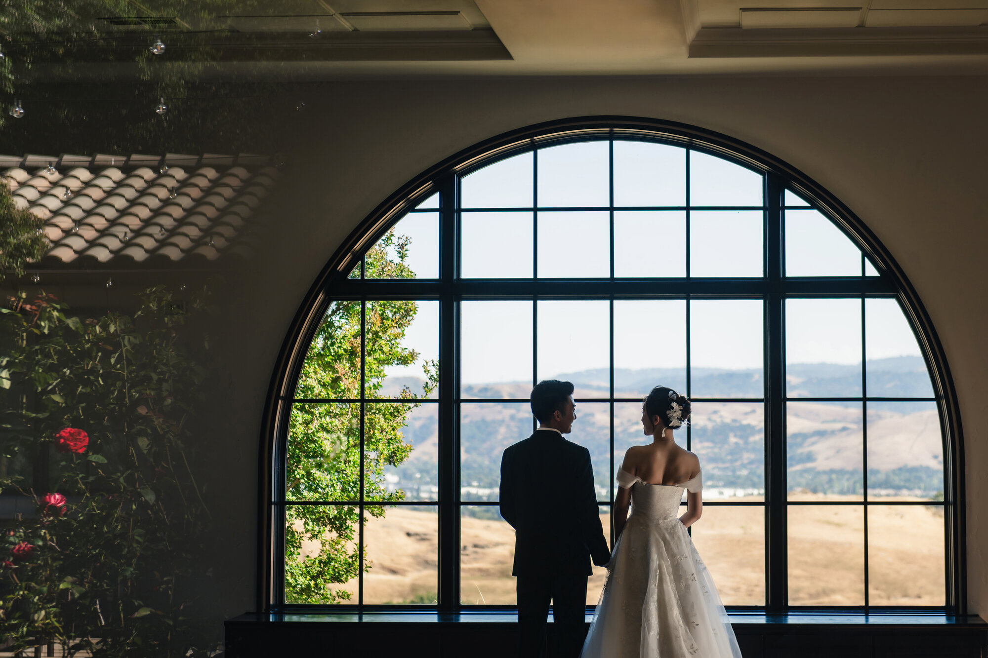 Wedding couple framed by an arched window